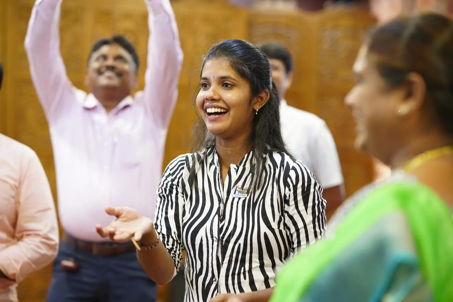 பயிற்சியின்போது கைகளை உயர்த்தி மகிழ்ச்சியாகச் சிரிக்கும் இரு பங்கேற்பாளர்கள்