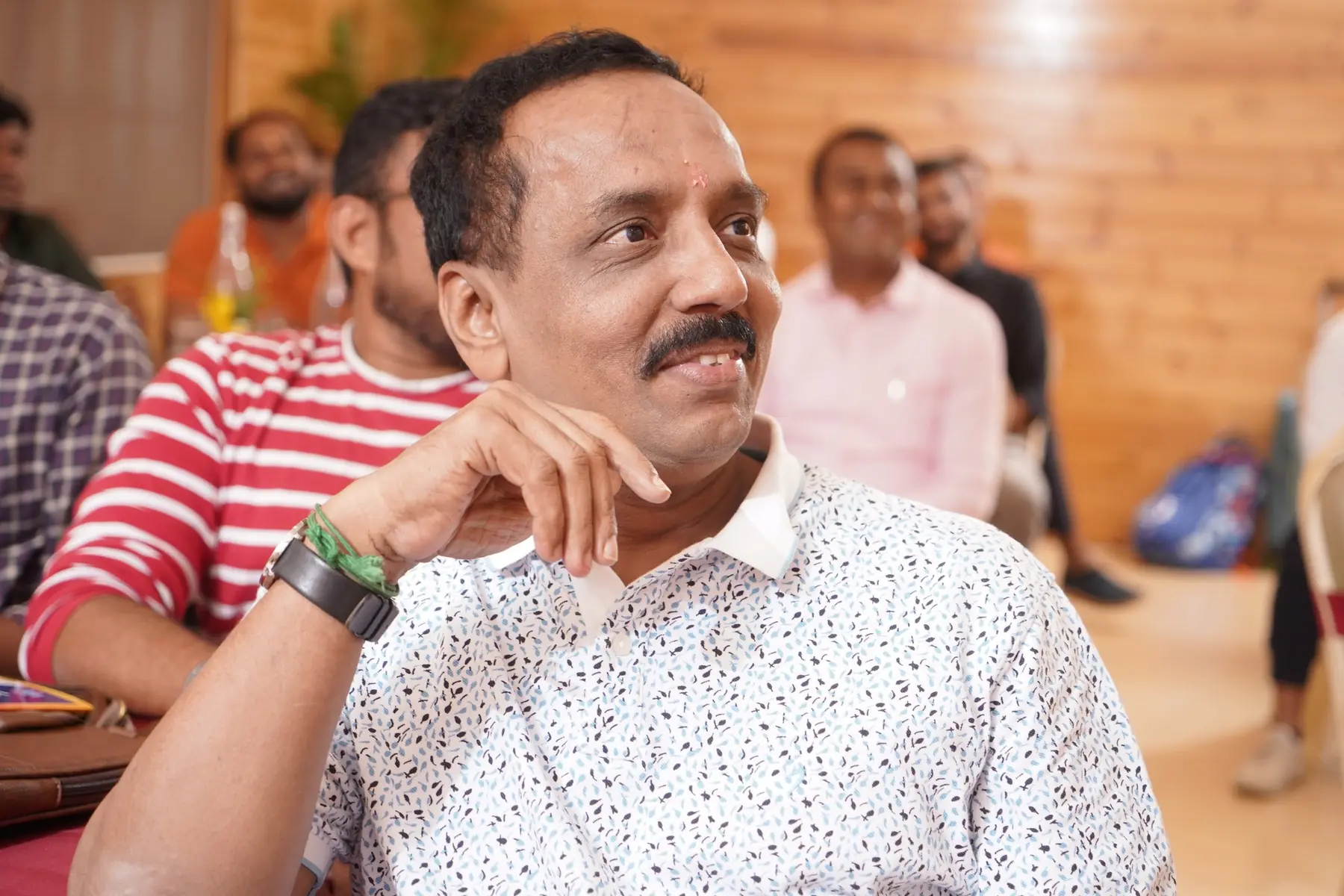 கவனித்தபடி புன்னகைக்கும் ஒரு பங்கேற்பாளர்