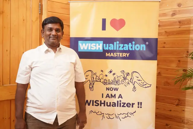 “Now I am a WISHualizer” என்ற பேனருடன் ஒரு பங்கேற்பாளர்